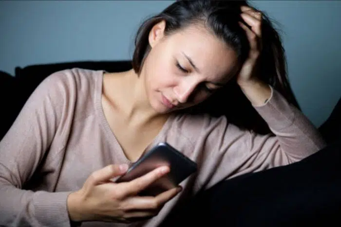 Moça aflita vendo o ex-namorado ignorar ela por mensagem de texto