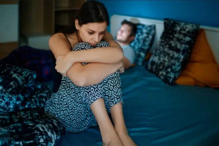 Mulher preocupada pensativa na cama com o namorado