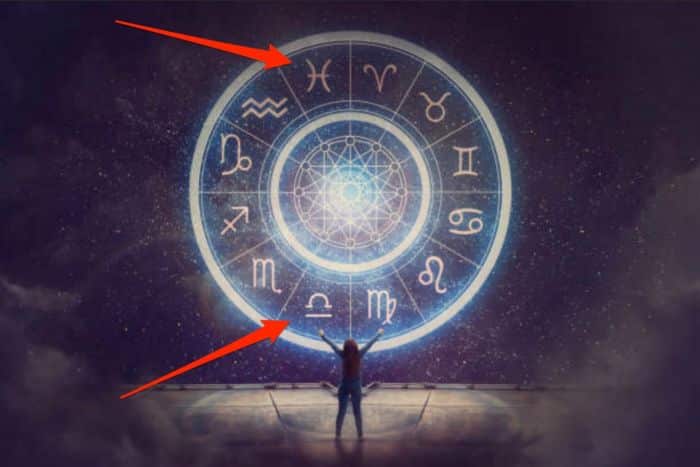 Mulher olhando para os símbolos dos signos do horóscopo, ênfase em libra e peixes
