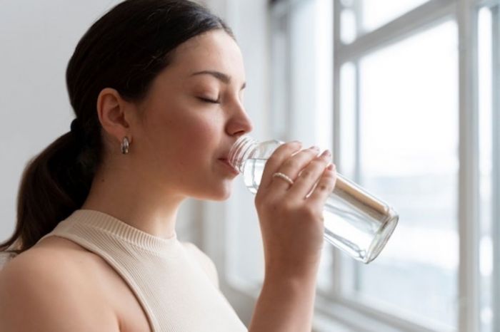 Mulher bebendo muita água para ficar mais atraente para o marido