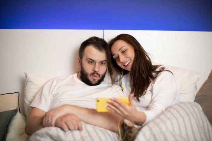 Casal assistindo pornografia na cama para deixar o marido com muito desejo
