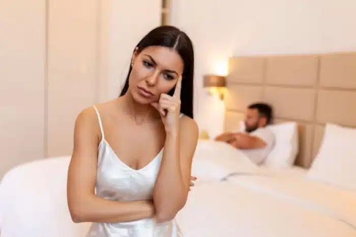 Mulher sentada do lado da cama frustrada porque o marido não a procura para fazer sexo