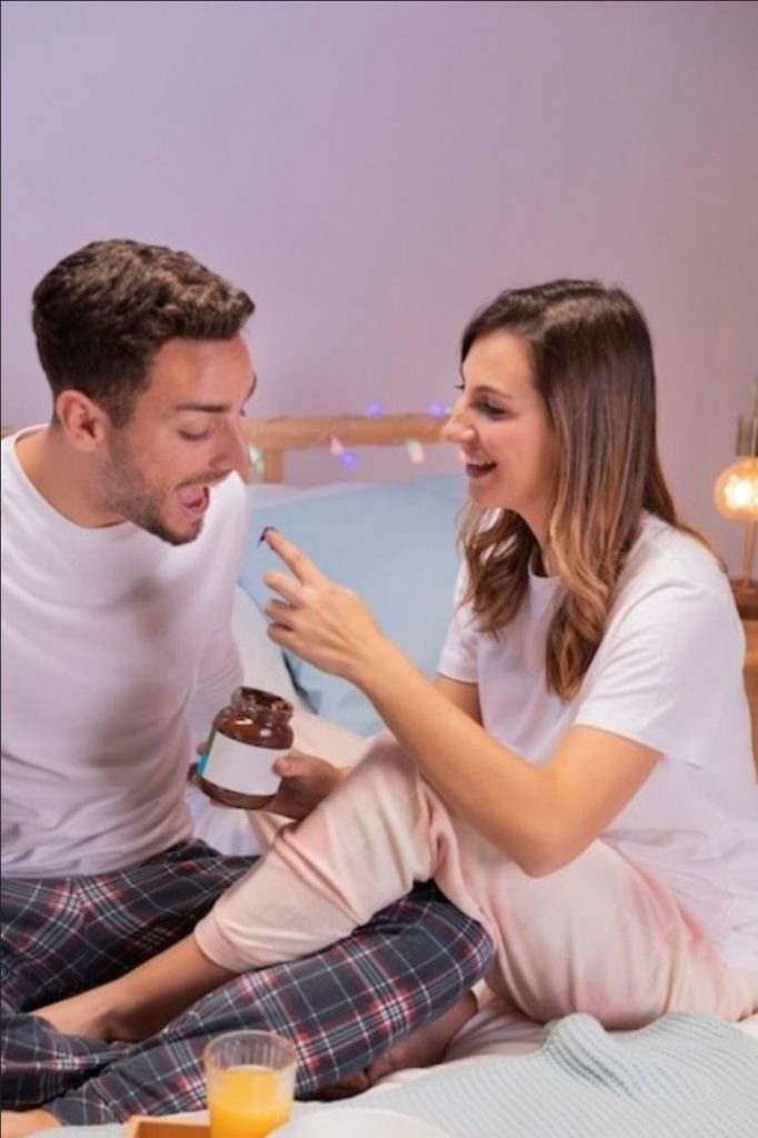 Moça dando chocolate para surpreender o namorado
