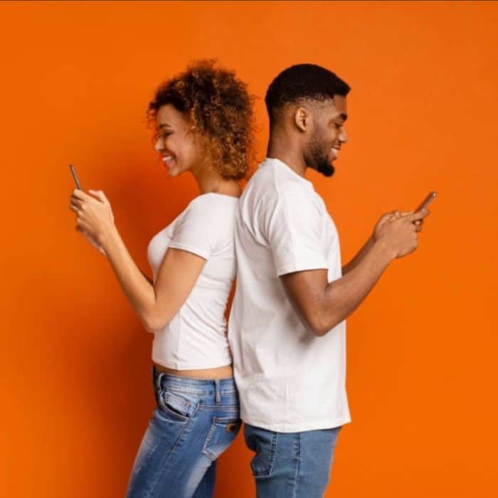 Rapaz e moça trocando frases de gatilhos mentais pelo celular

