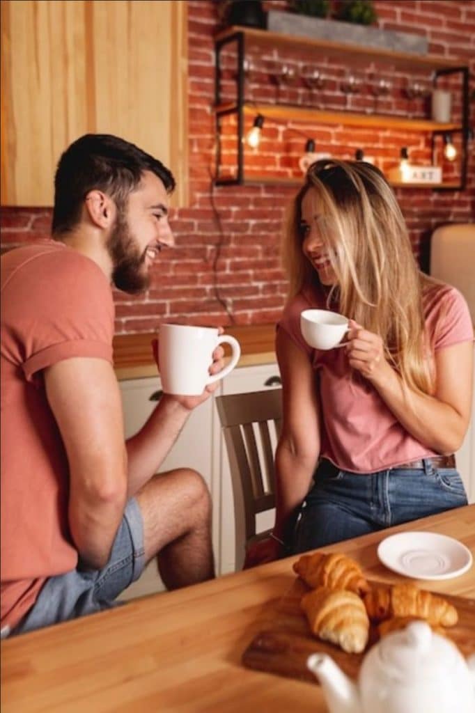 homem e moça conversando tomando café
